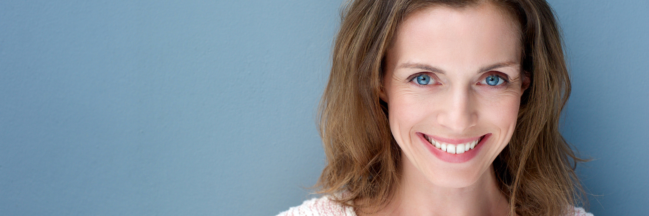 How I Became Empowered After an Osteoporosis Diagnosis A woman smiles at the camera, joy filling her eyes.