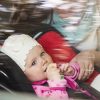baby girl in child seat in car with mother next to her
