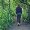 Woman walking on path in forest.