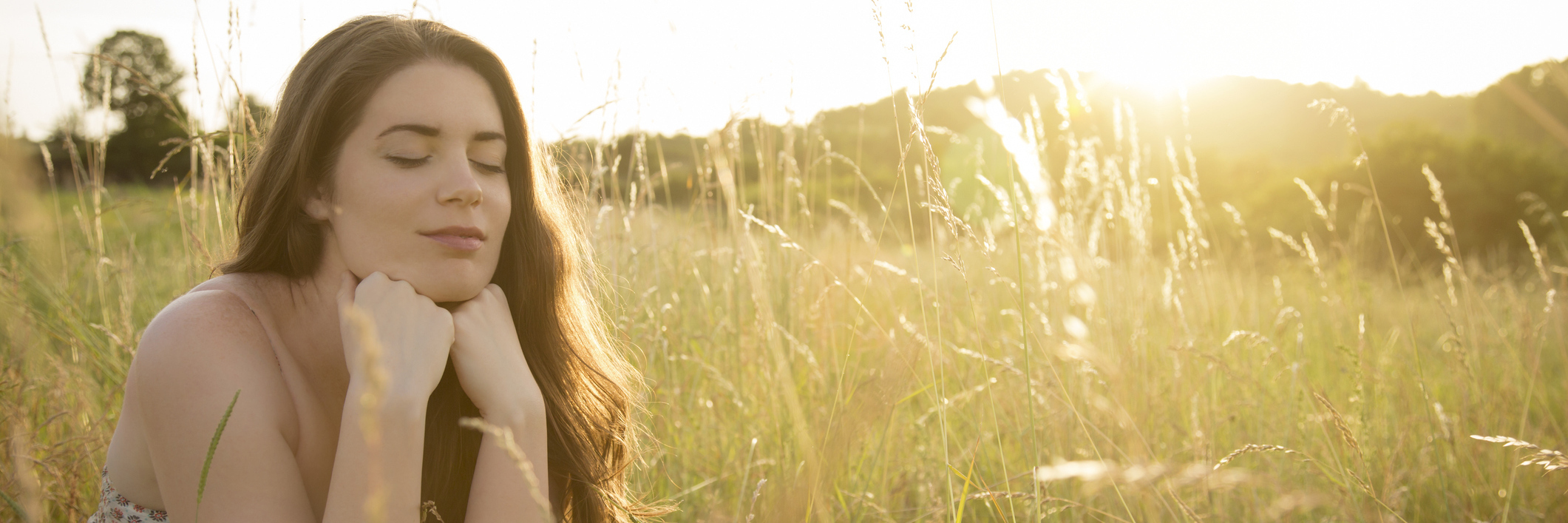 woman sitting in a field smiling