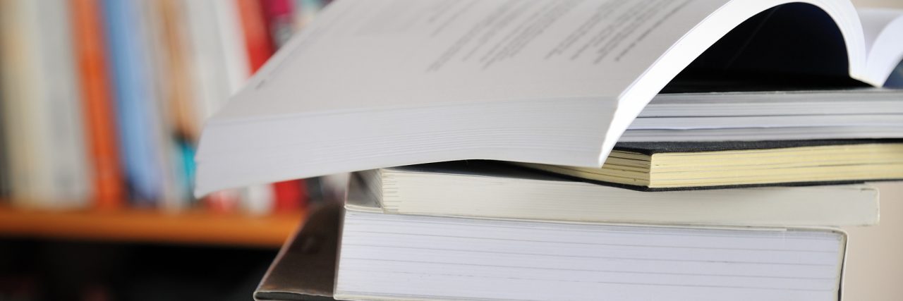 College Student's Guide to Disability Accommodations Stack of books on table in library.