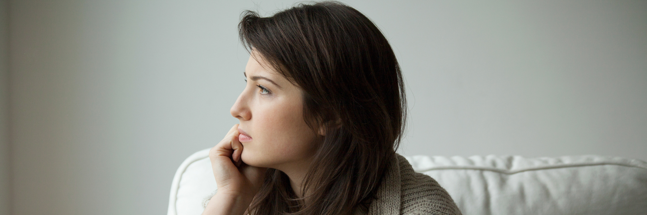 Being Misdiagnosed Before Learning the Signs of Ovarian Cancer woman sitting on the sofa and thinking