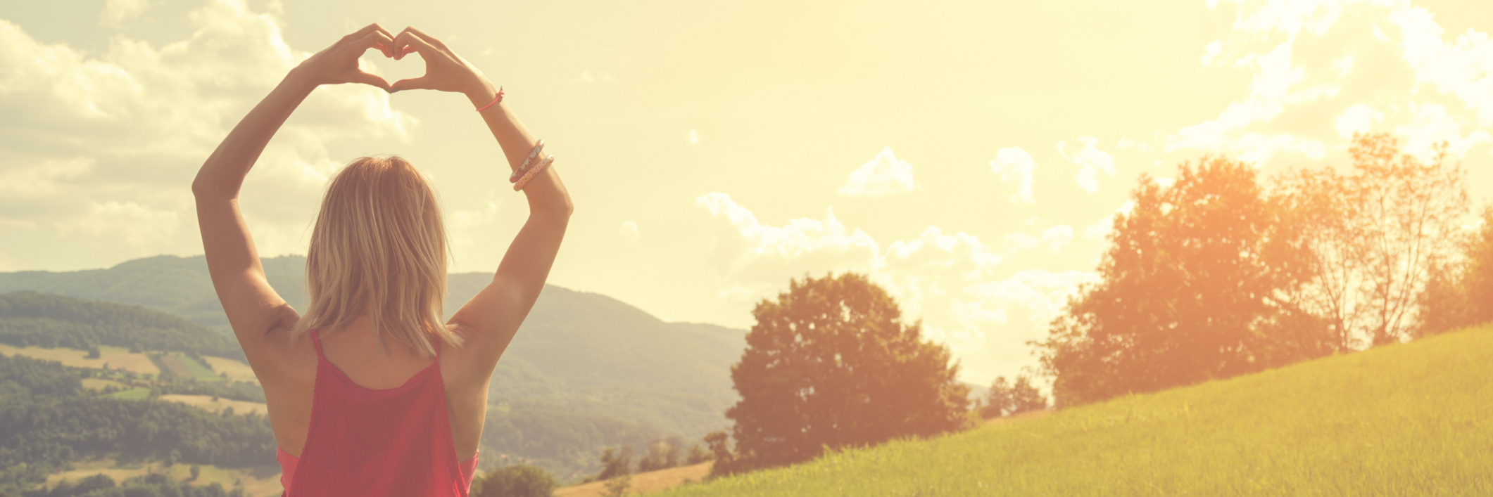 What Borderline Personality Disorder Is: A Poem woman standing in field at sunset making heart shape with hands
