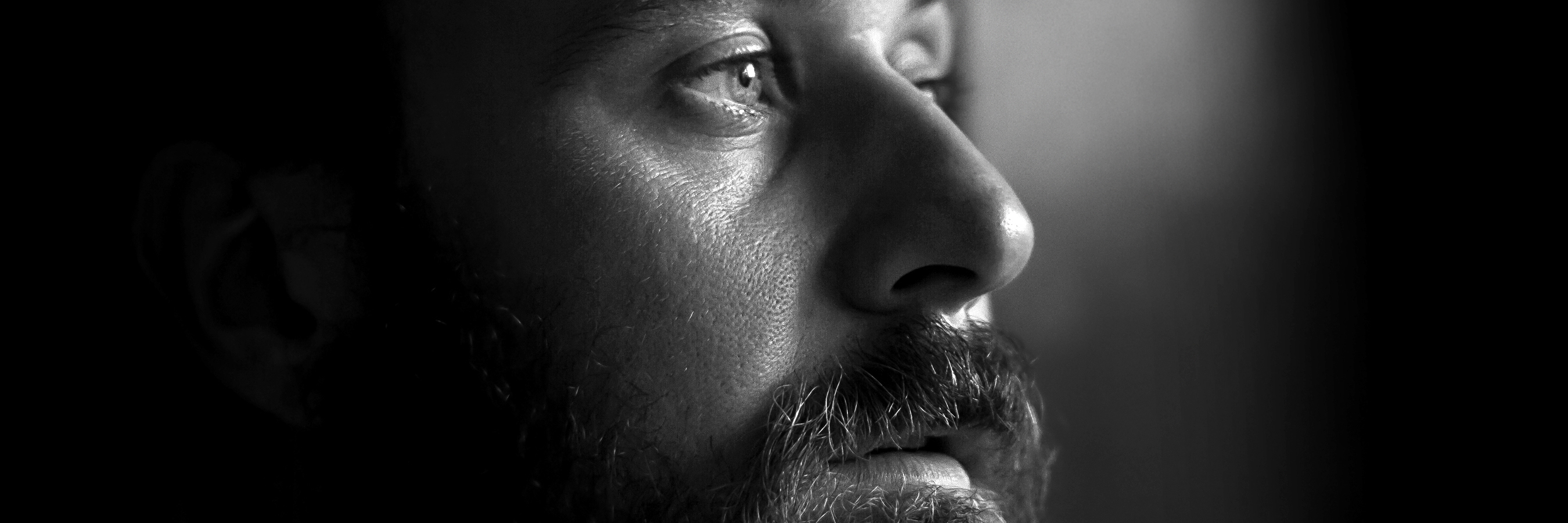 How Blogging Became My Escape From Anxiety and Depression Close-up photo of a serious man with a beard in profile. Black and white image with shallow depth