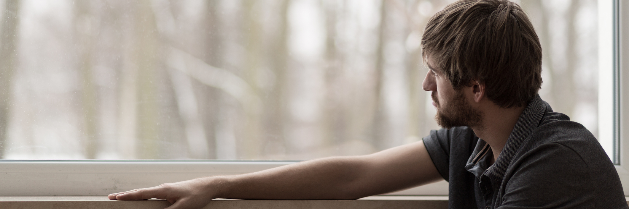 Robert Castleberry Fired One Day After Disclosing He Has Autism Young man who looks sad looking out the window at trees