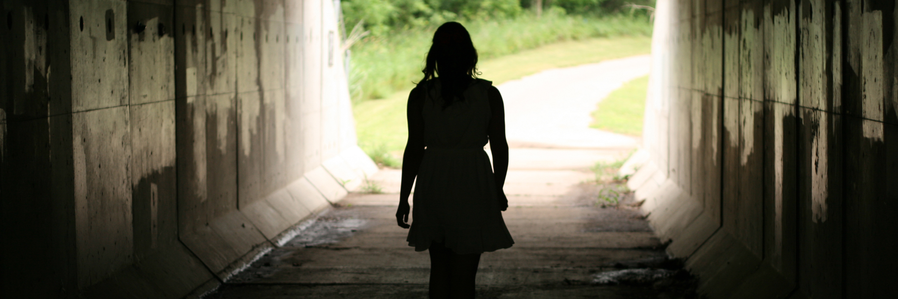 What Recovery Does and Doesn't Mean With a Mental Illness young woman walking through tunnel with light and trees at end