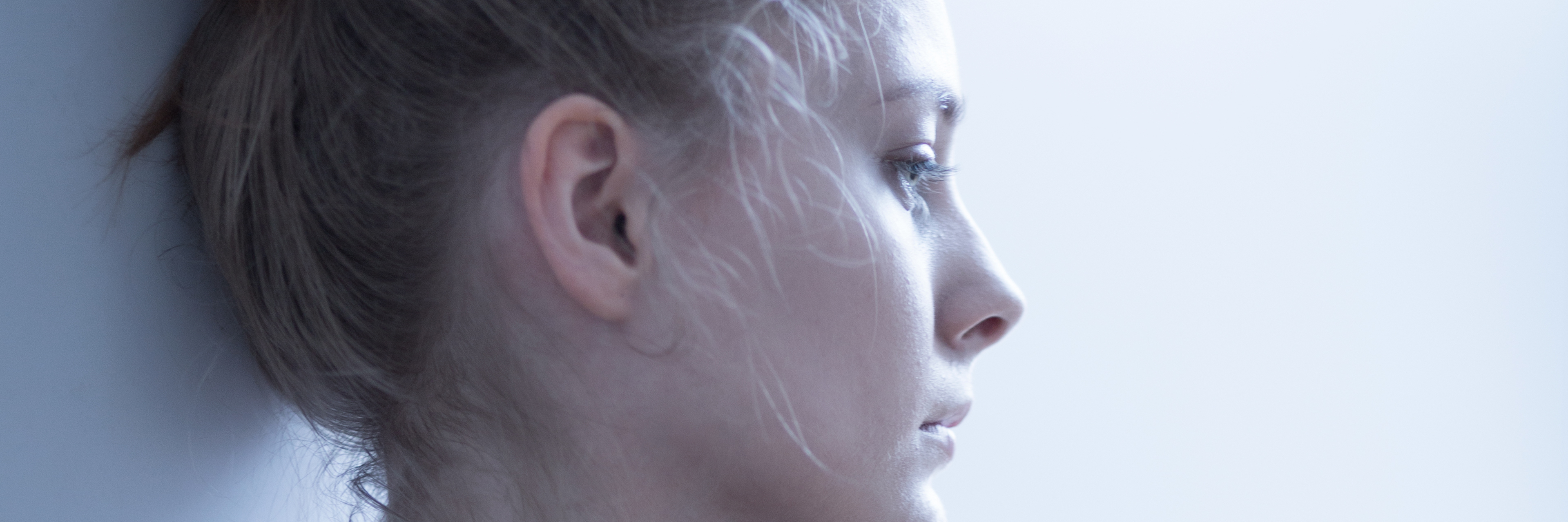 To Those Who Say, 'It's Just a Bruise' Woman looks away from camera with worry.