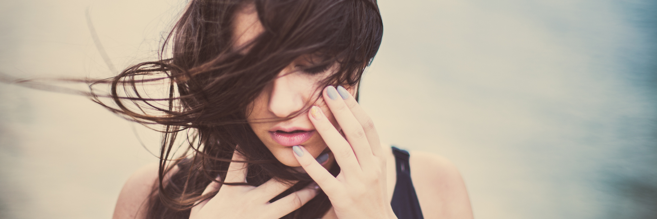 Advice for Finding Love Again After Relationship Abuse woman near lake with windswept hair looking upset
