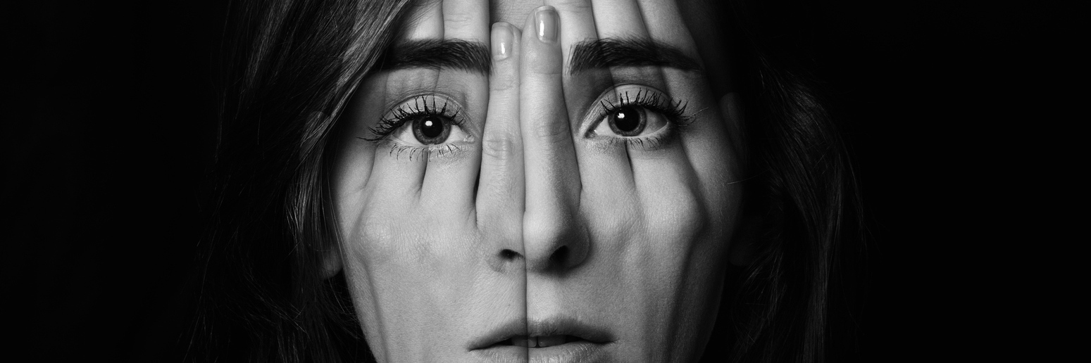 Surreal portrait of a young girl covering her face and eyes with her hands.Double exposure. Black and White.
