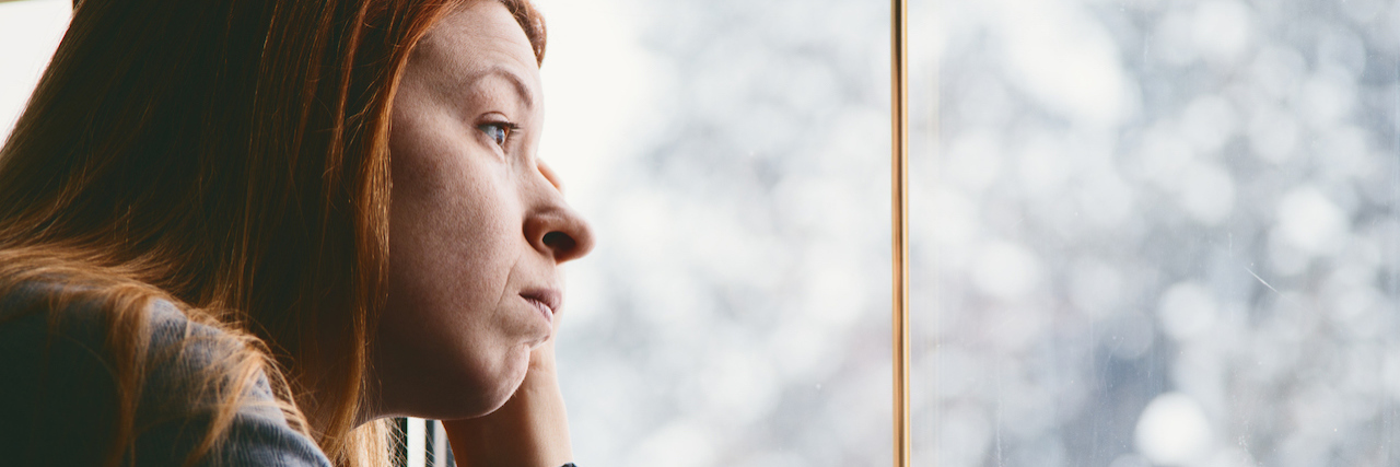 5 Practices That Have Helped Me Get Through Seasonal Depression woman looking out window