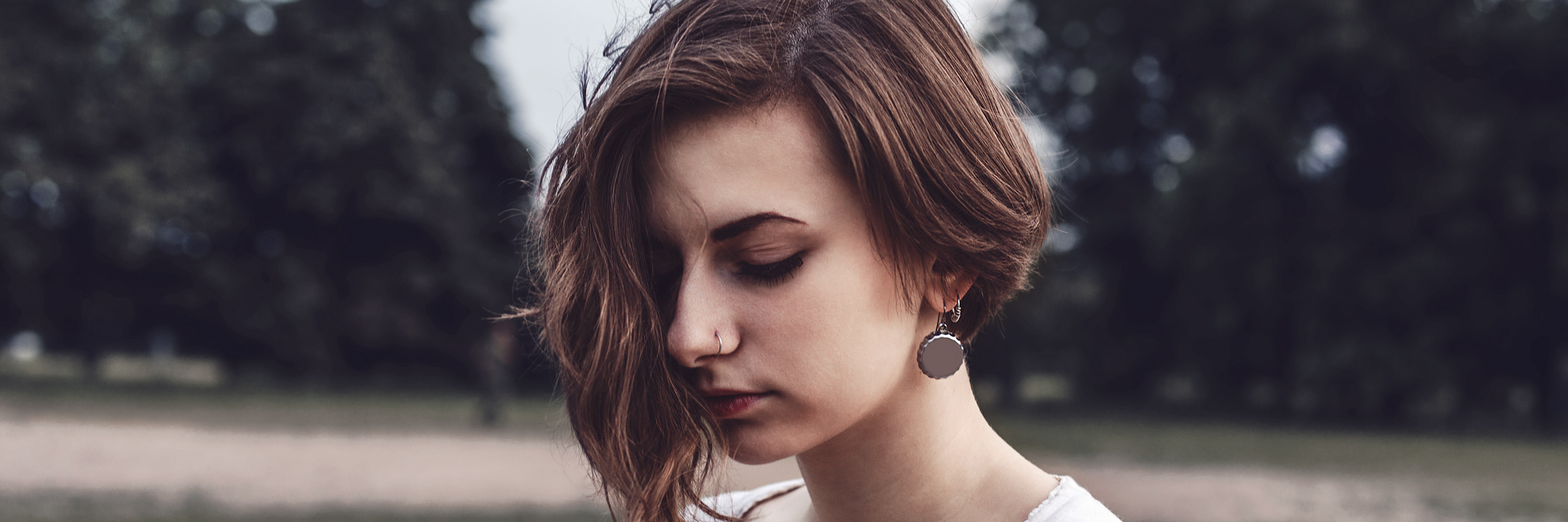 5 Reasons Rheumatoid Arthritis Is a Daily Struggle A woman looking towards the ground, serious in thought.