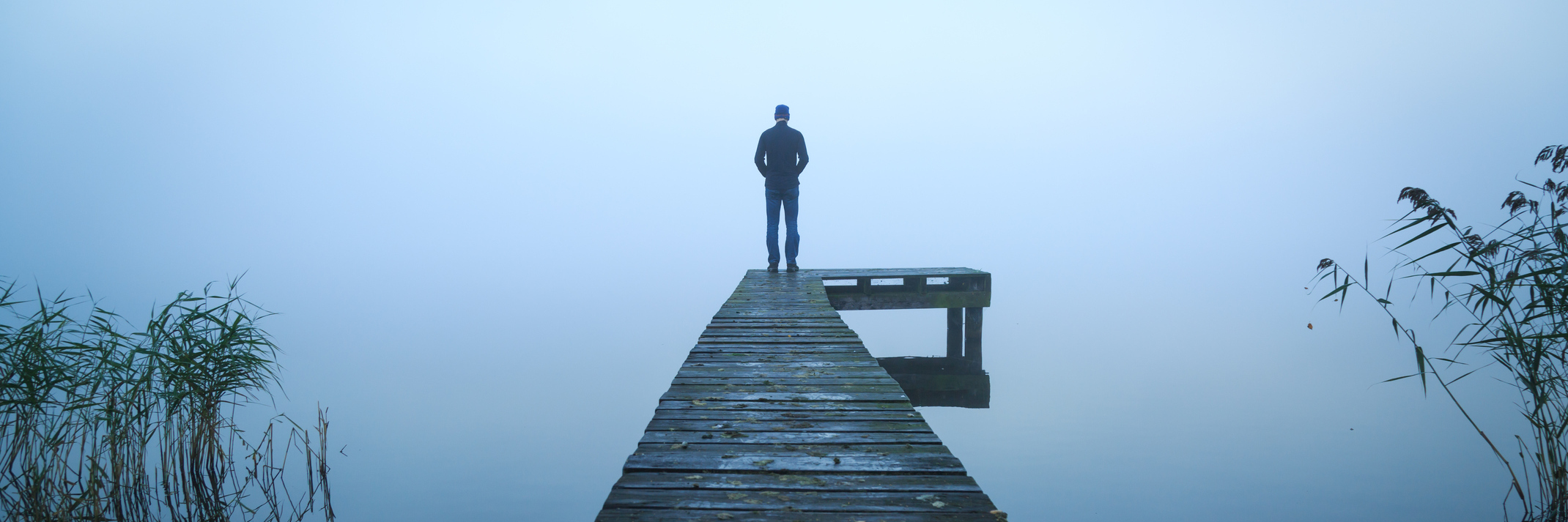 Reasons Why Depression Can Trigger Anxiety man standing alone on jetty over water on foggy day
