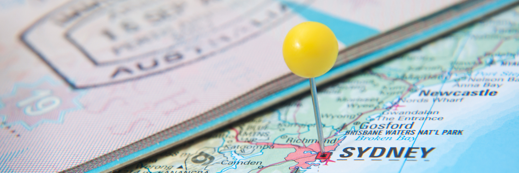 8 Things I've Learned Living Overseas With a Rare Disease A photo of a passport on top of a map, with an Australian stamp and a pin marking the country.