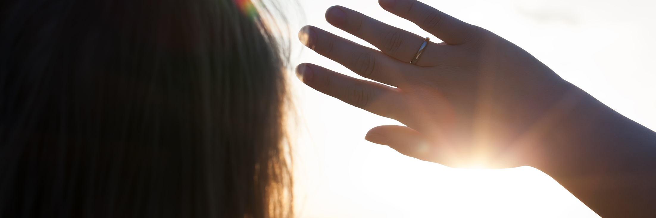 My Depression Makes Me Have a Love-Hate Relationship With Sunny Days Back close-up shot of a woman looking in the distance hiding from the sun with a hand