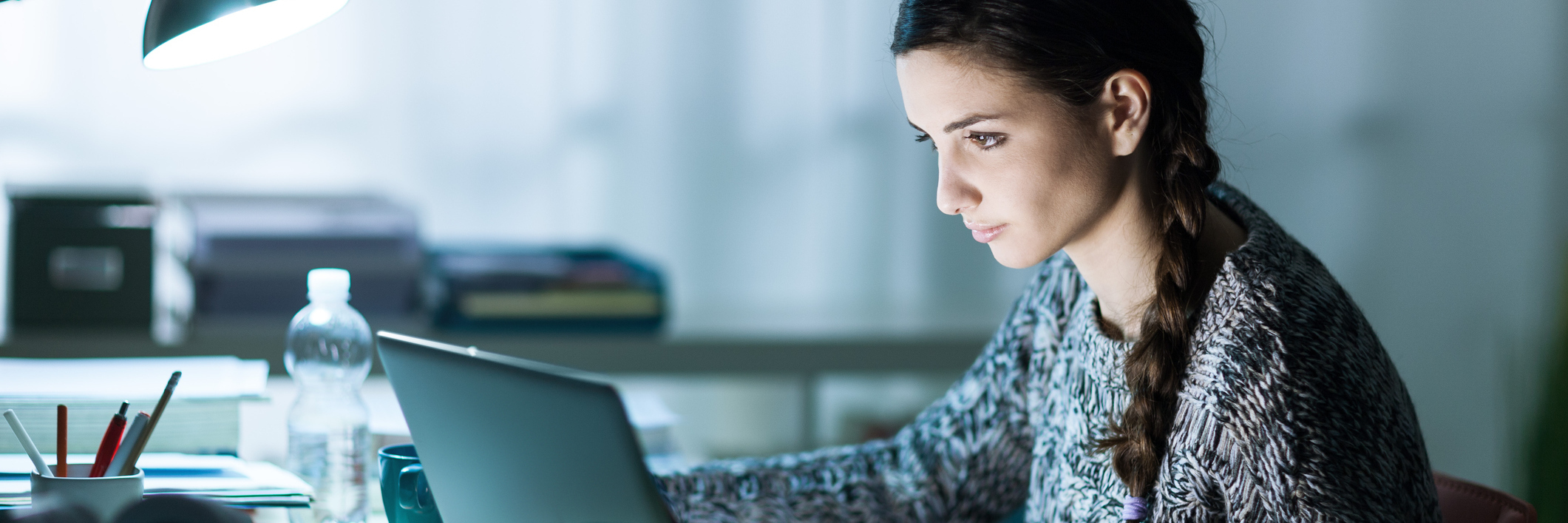 Going Through High School, Getting Into College With Chronic Illness woman studying at home with her computer on her desk