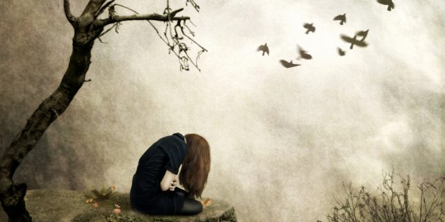 Things I Shouldn't Feel After My Cancer Diagnosis Lonely girl sitting on a rock in sorrow