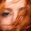 A close-up on a red-headed woman's eyes.