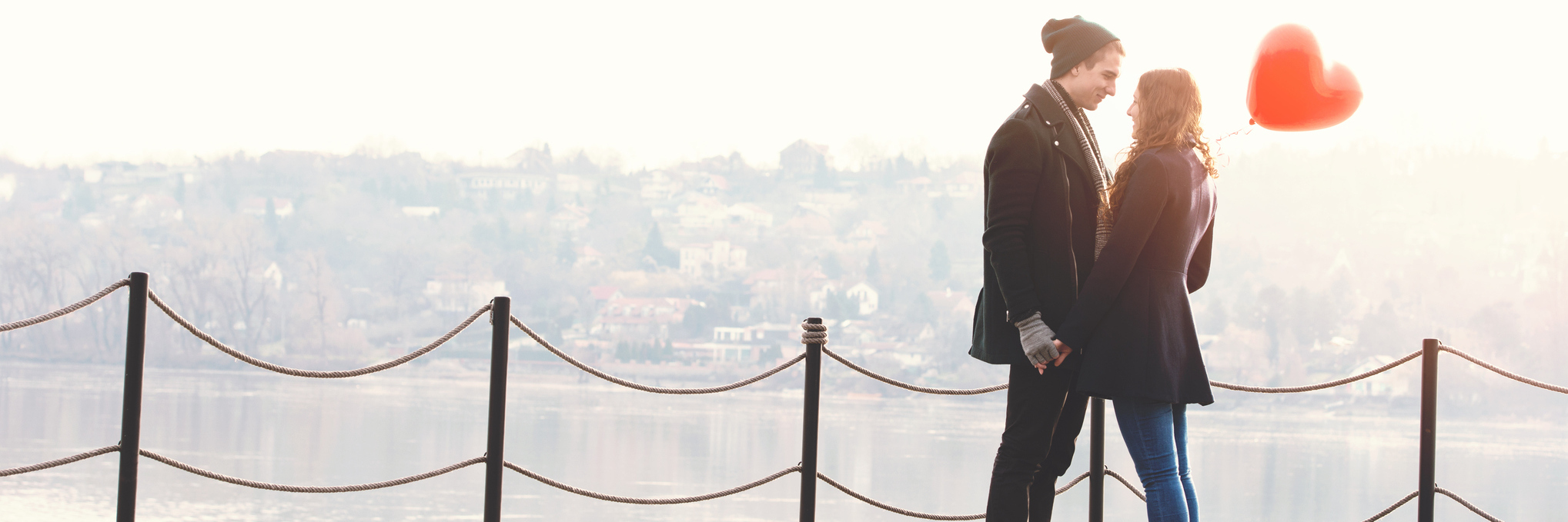 To My Fiancé, Thank You For Helping Me Conquer My Illness A young couple standing near a railing outside, with a heart shaped balloon.