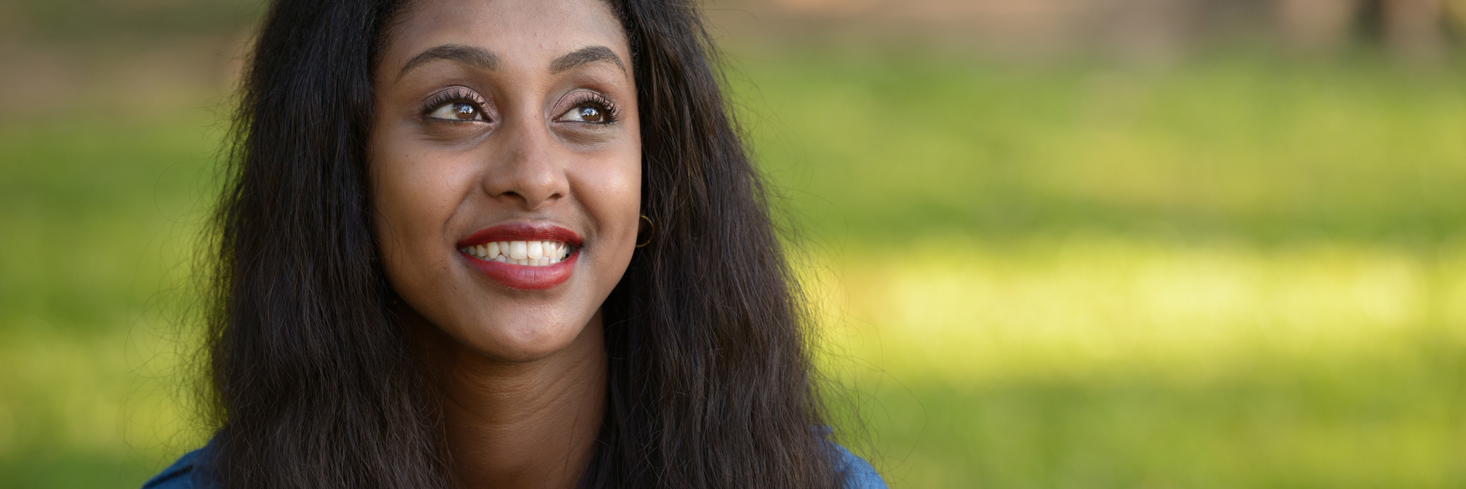 There's Nothing Wrong With Saying You're in Mental Health Recovery young woman in dark smiling in sunshine