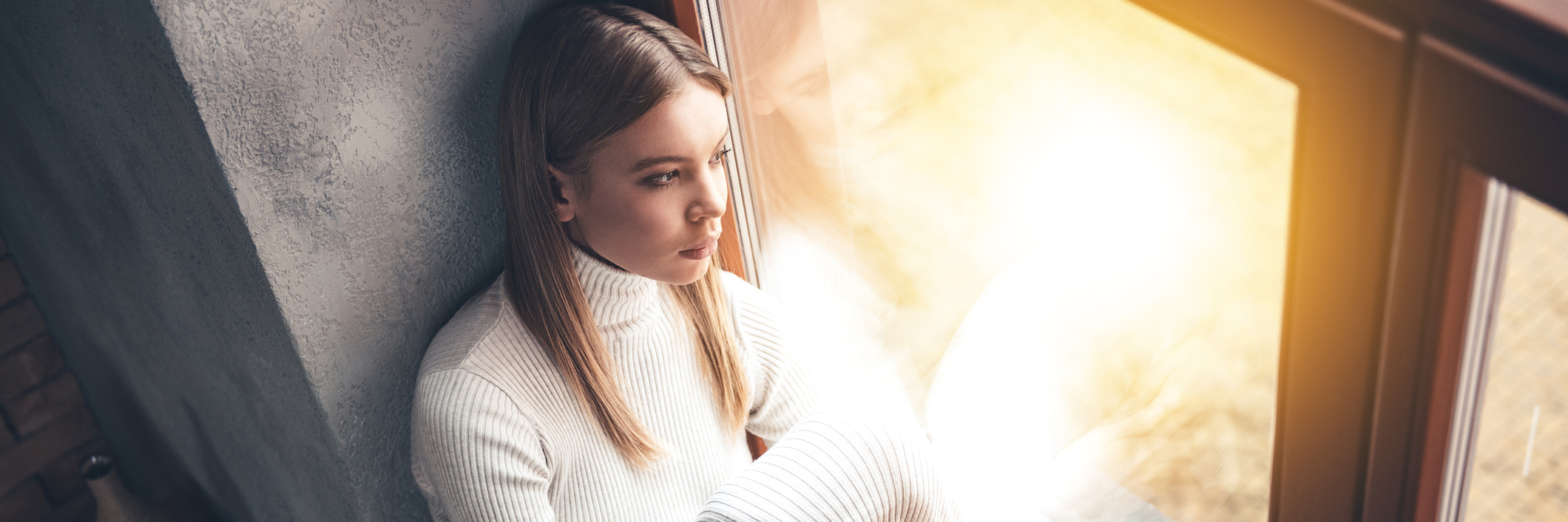 When Your Chronic Illness Affects Your Friendships A woman sitting alone, looking out a window.