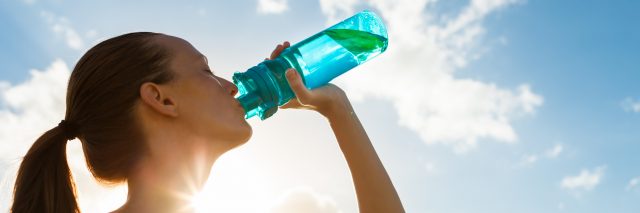 Woman drinking a fresh water from bottle.