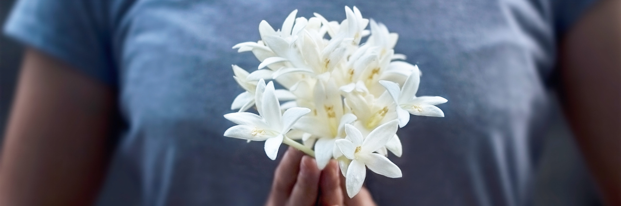 5 Quotes That Help Me Through the Difficult Mental Health Days A woman holding flowers