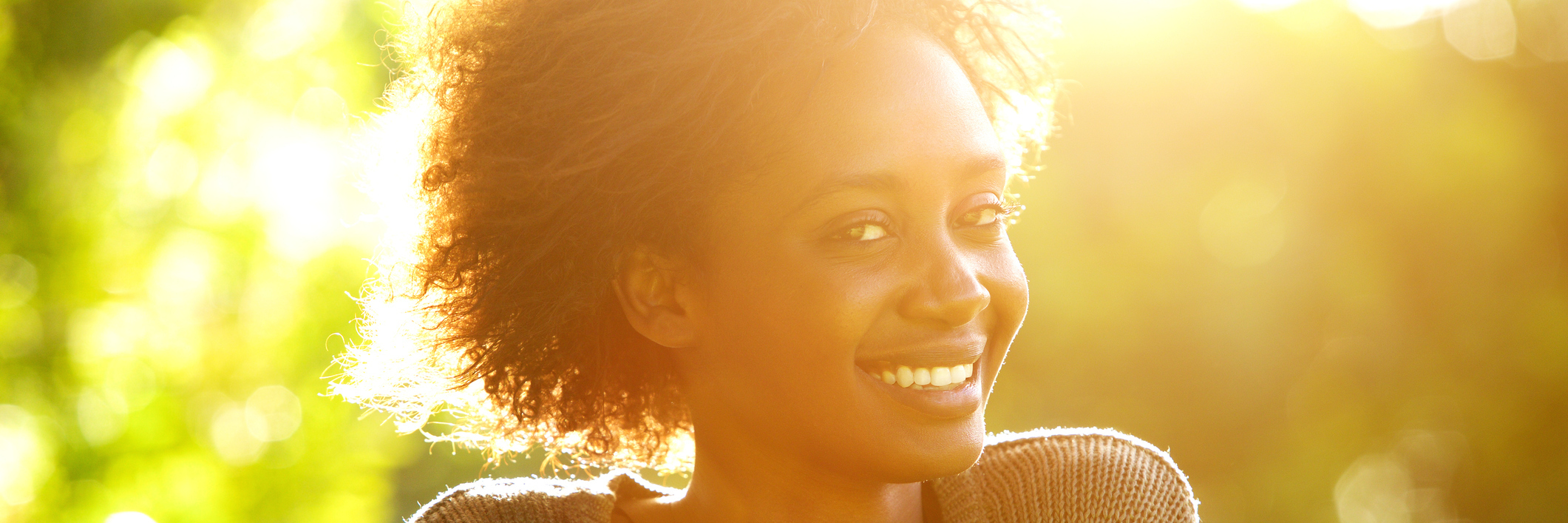 Smiling Black woman at sunset.