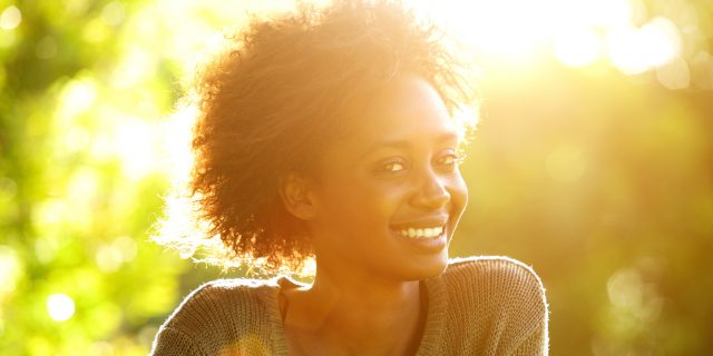 I'm a Black, Autistic Woman and I'm Not Alone Smiling Black woman at sunset.