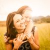 mother and daughter hugging in field smiling