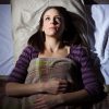 young woman lying in bed unable to sleep lost in thought