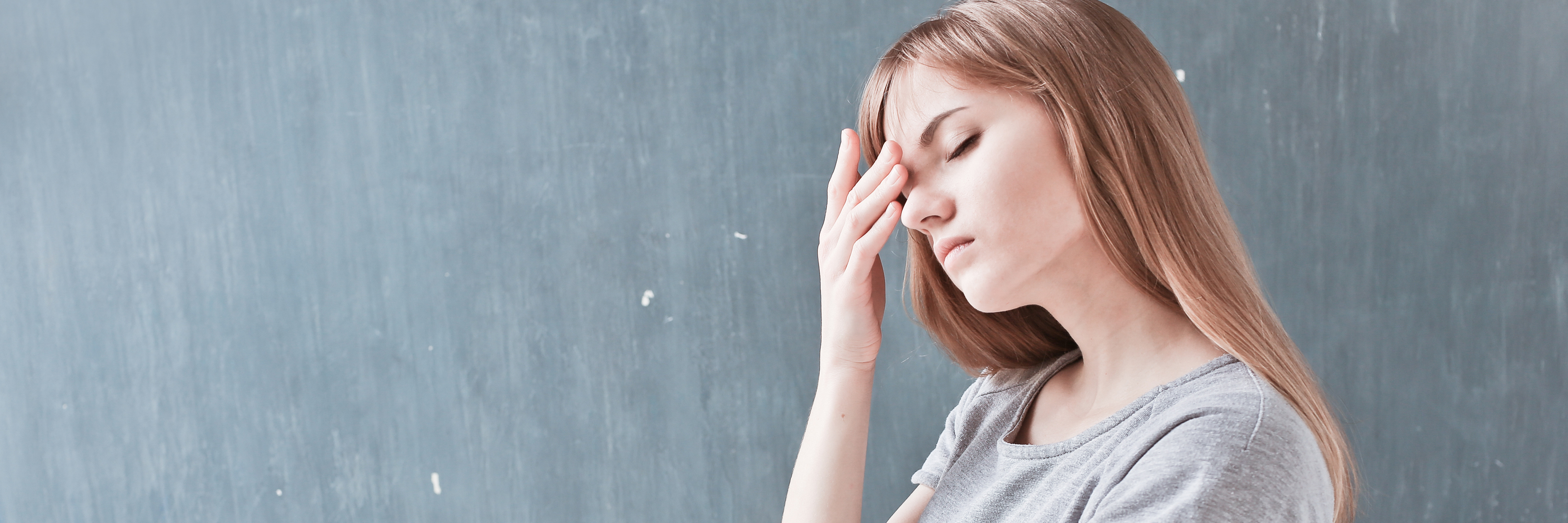 When Intrusive Thoughts Ruin a Family Outing young woman against gray background looking stressed or upset