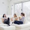 three women sitting on a couch and talking