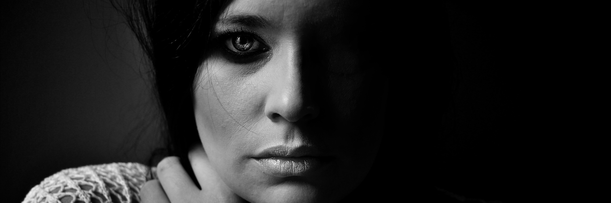 Black and white image of a woman looking seriously into camera.