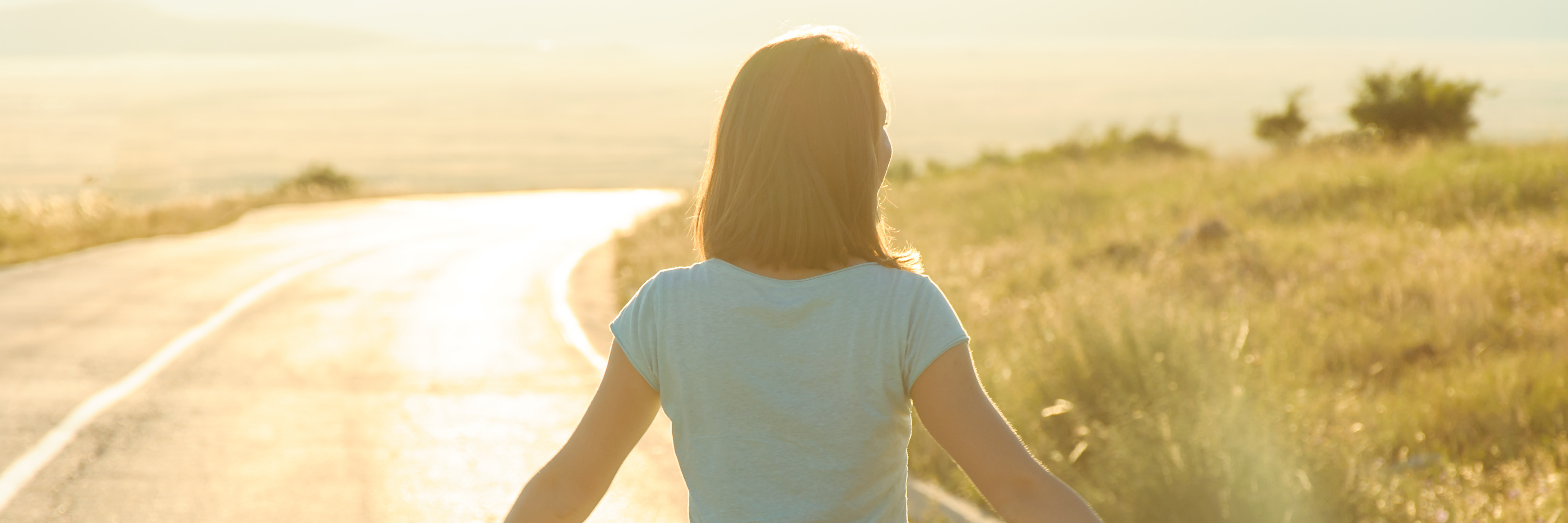 How Accepting Chronic Illness Is a Long and Difficult Journey woman walking down a road in the sunshine