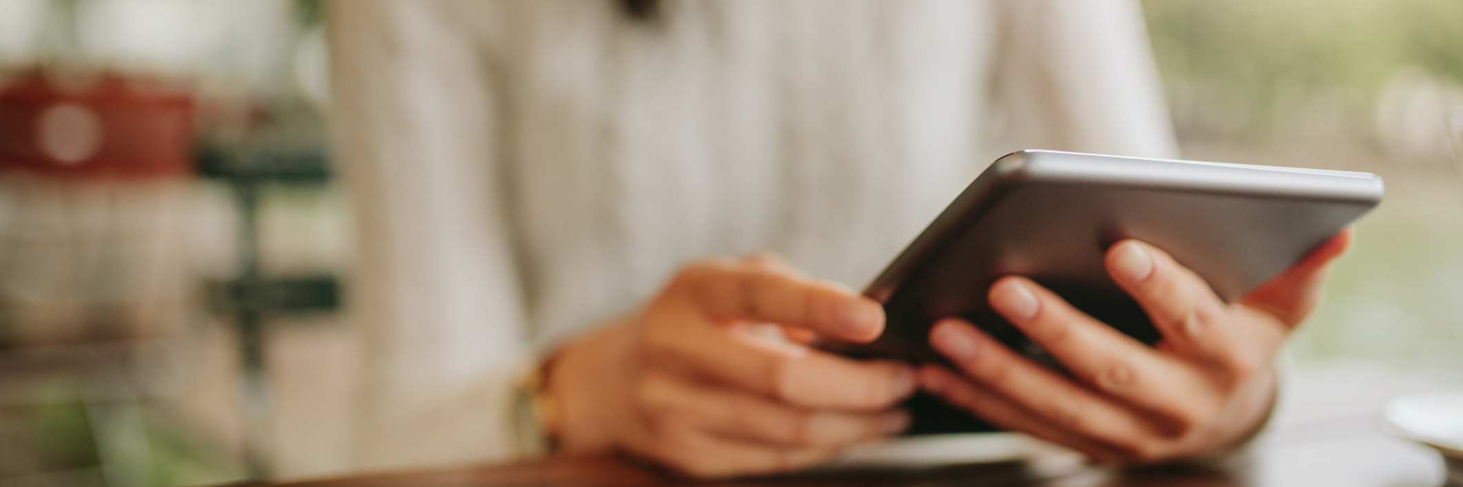 8 Tips to Help You on Your Chronic Illness Journey Woman sits at coffee shop reading her tablet.