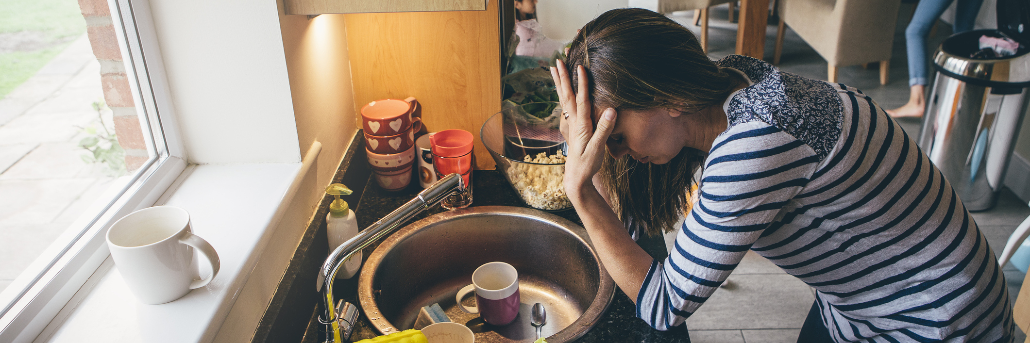 To the Chronically Ill Parent Who Feels Like a Failure A mom doing dishes, stressed out with children in the background.