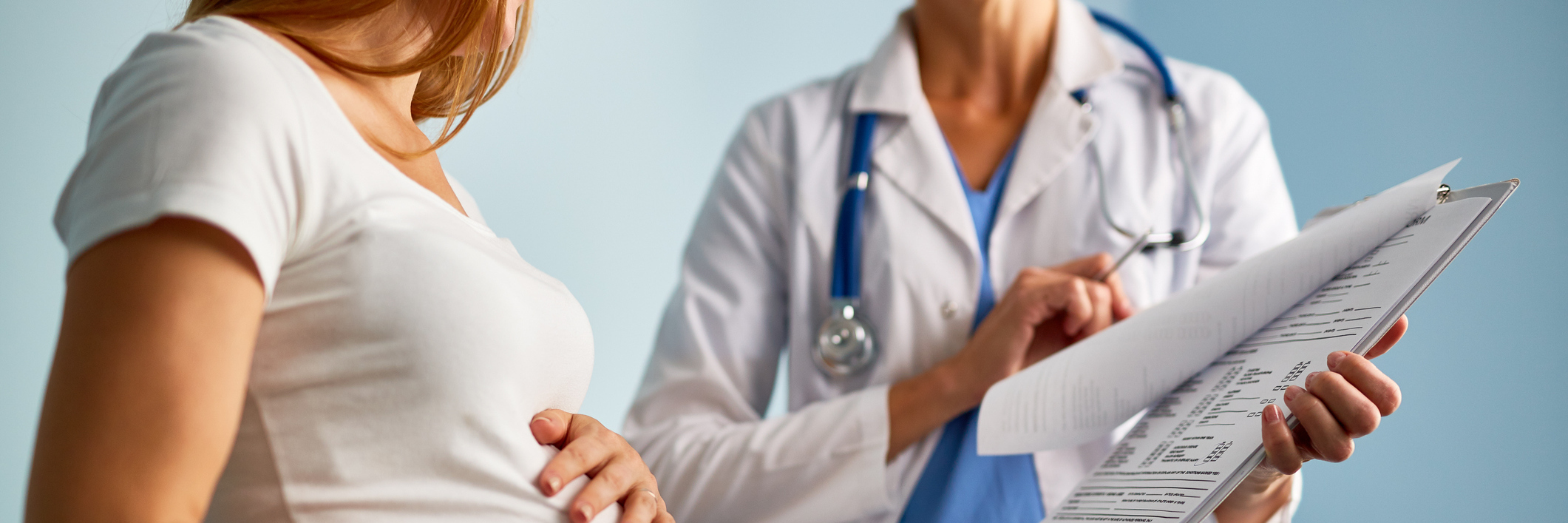 When Your Physician Disregards Your Mental Illness pregnant woman talking to doctor being shown something on clipboard chart