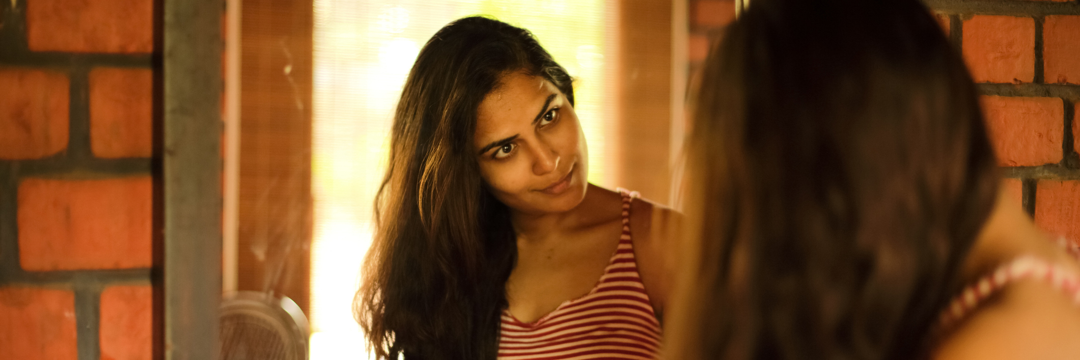 Breaking the Stigma of Mental Health Means Expressing My Emotions A woman looking in the mirror