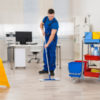 Male janitor mopping floor in office.
