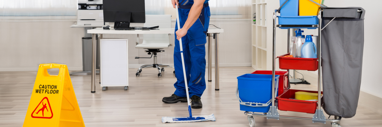 Finding Success At Work as a Person With Asperger's Male janitor mopping floor in office.