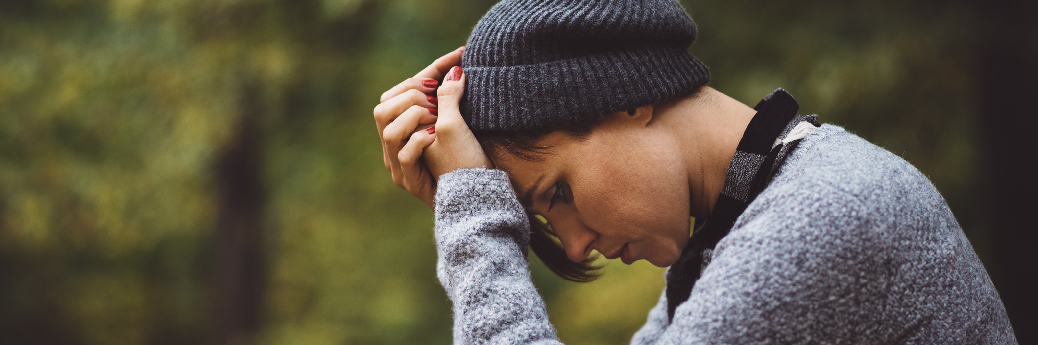 The Most Important 'Adulting' Lesson I Learned in a Doctor's Office A struggling woman, outside, her head in her hands.