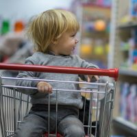 young boy in shopping cart