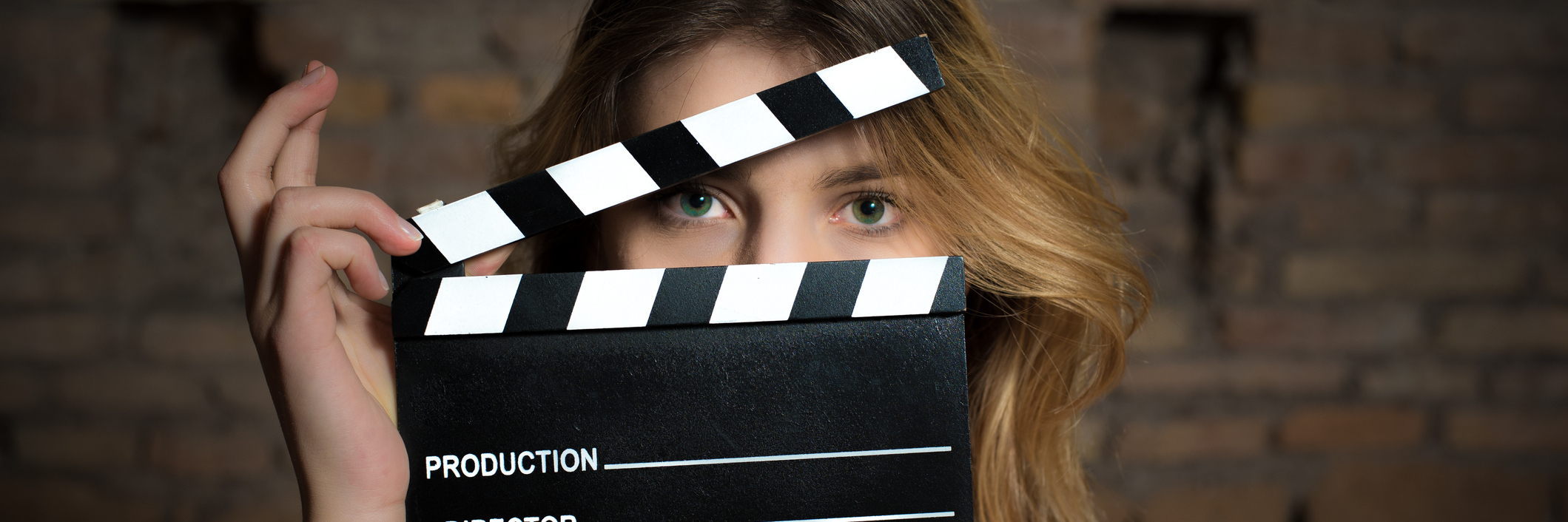 Acting and Putting on a Mask When You Have a Chronic Illness woman holding up a movie clapper in front of her face