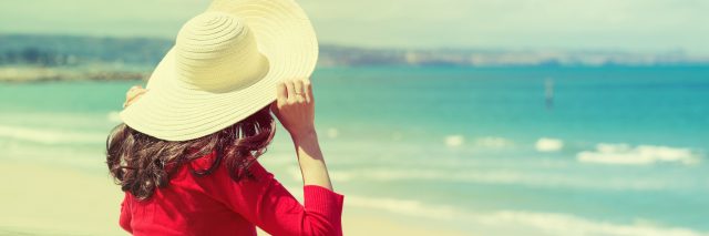 woman wearing hat looking at ocean