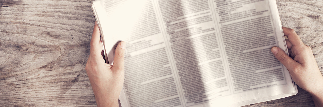 Why the Media Needs to Follow Reporting Guidelines After a Suicide woman holding newspaper