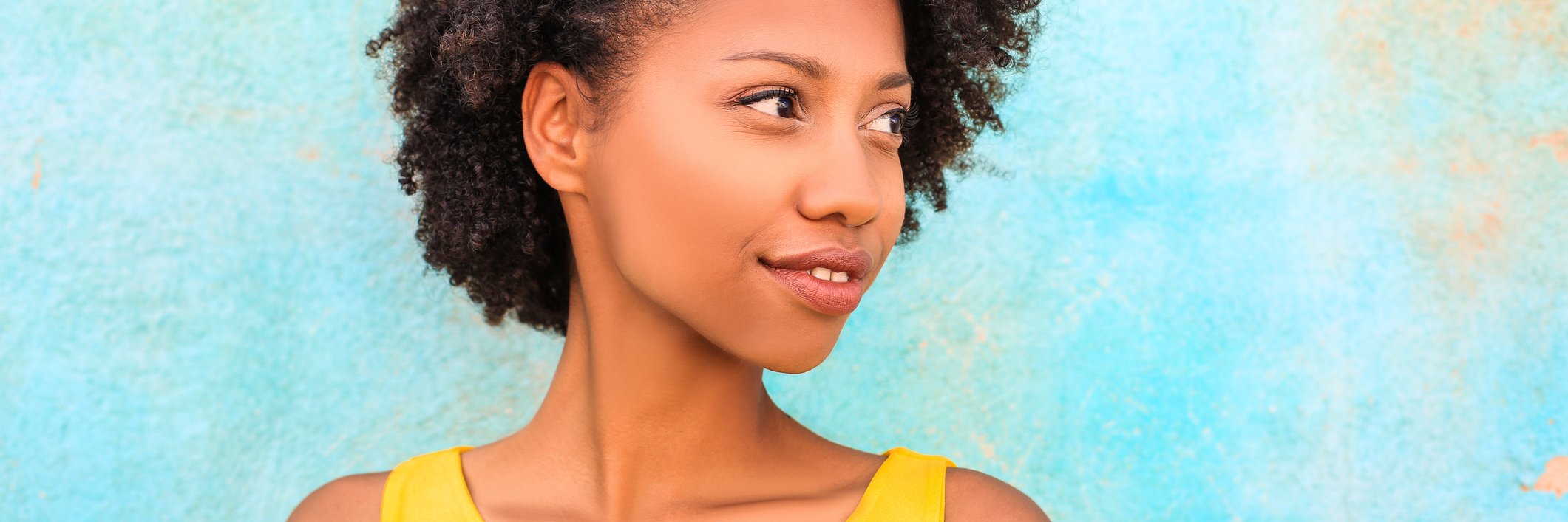 My Mental Illness Helped Me Come Out About My Sexuality young woman wearing yellow shirt in front of blue wall