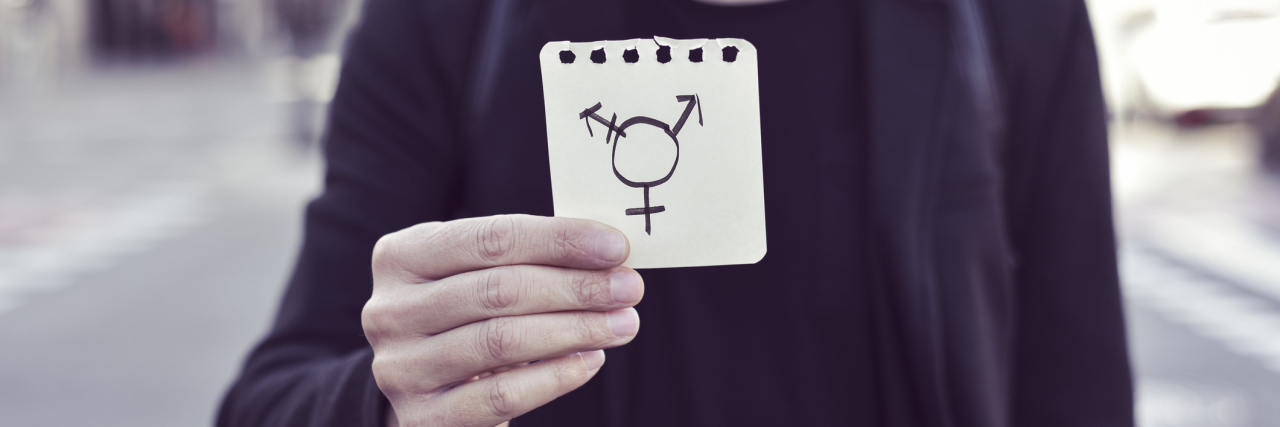 Being Transgender and in the Military Does Not Mean Suicide man in blazer holding transgender symbol on notepad