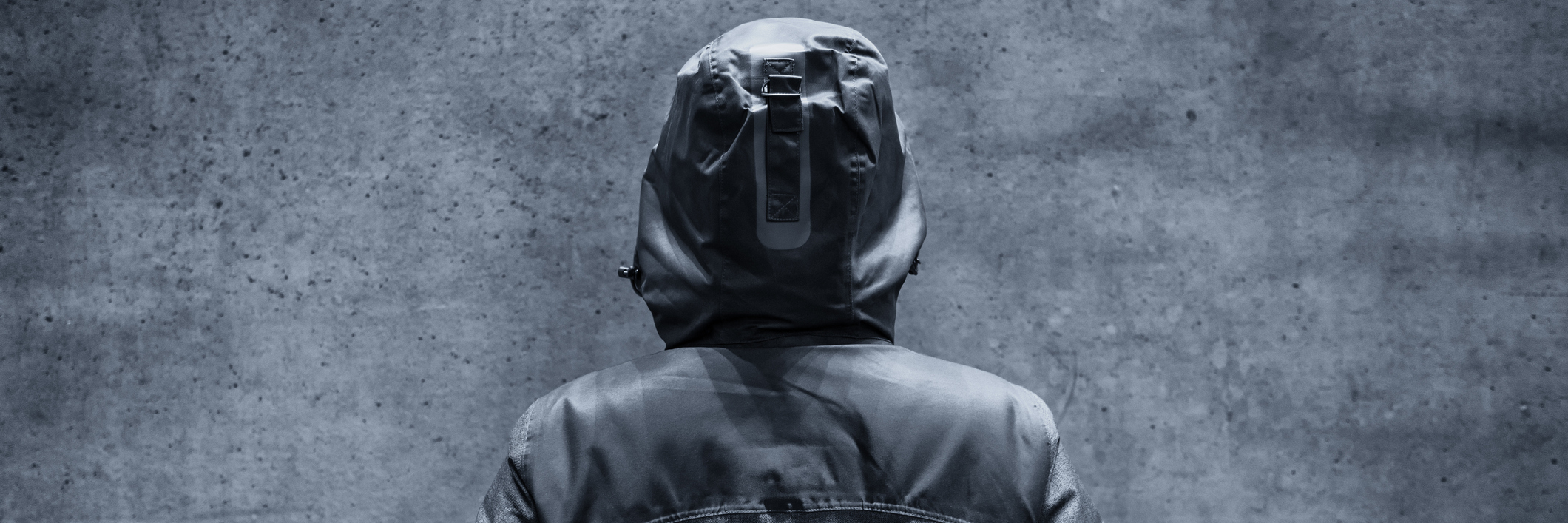 When You're Diagnosed With an Incurable Disease You Didn't Plan For A woman in a hoodie looking at a cement, blank wall.