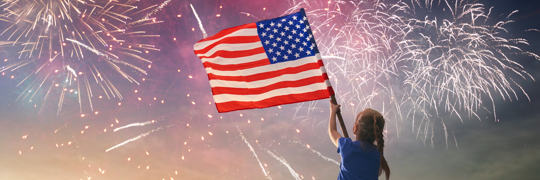 Fourth of July: Having Freedom and Independence With Chronic Illness young girl waving an american flag in the sky with fireworks
