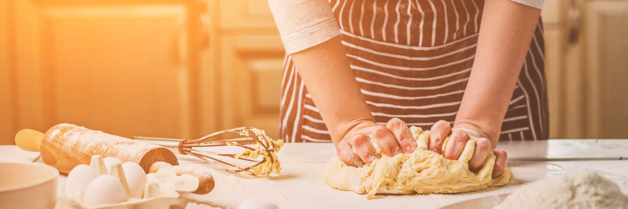 Autism Makes Me a Baker in the Recipe of Life Woman kneading dough on kitchen table.